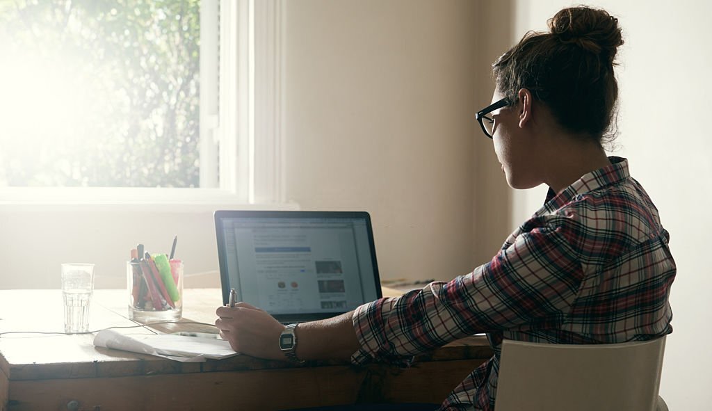 Žena zachytená pri programovaní webovej stránky na laptope